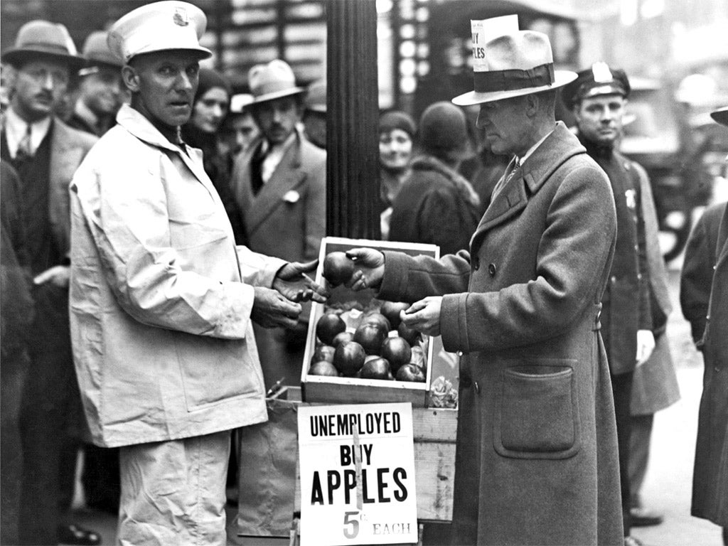 A jobless man sells apples on a US street during the Depression