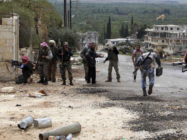 Members of the Free Syrian Army watch for snipers during fighting against pro-government forces in Harem town yesterday