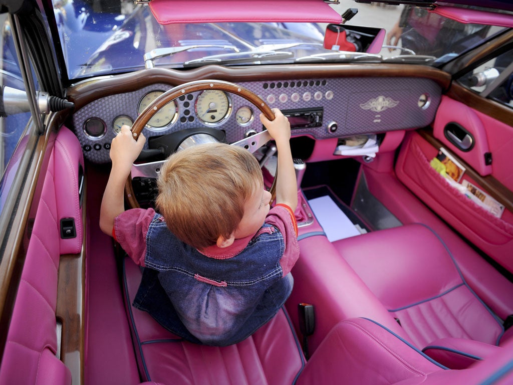 A Kosovar child sits in a Morgan car during a parade of Old Timer Cars in Pristina on May 31, 2009