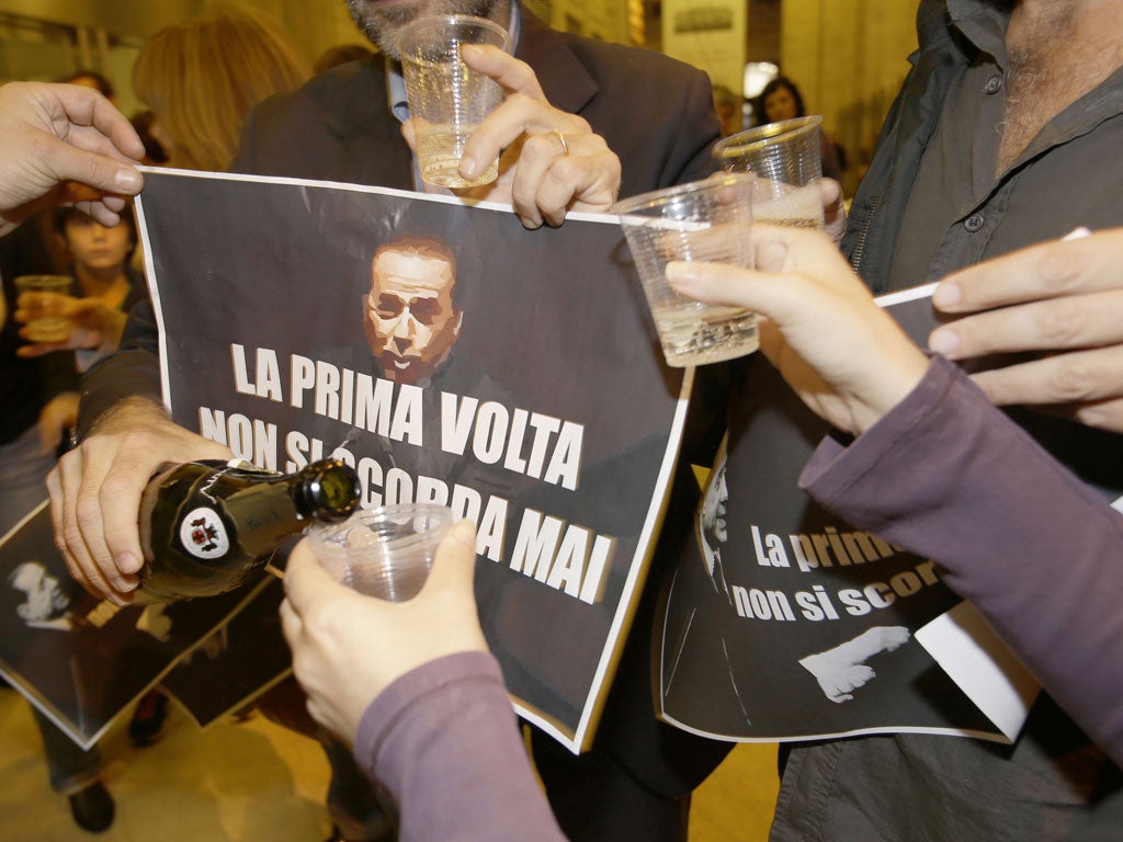 Gianfranco Mascia, a blogger who organised protests against former premier Silvio Berlusconi, raises a glass with campaigners following the sentence announced against Berlusconi, near the Italian Parliament in Rome