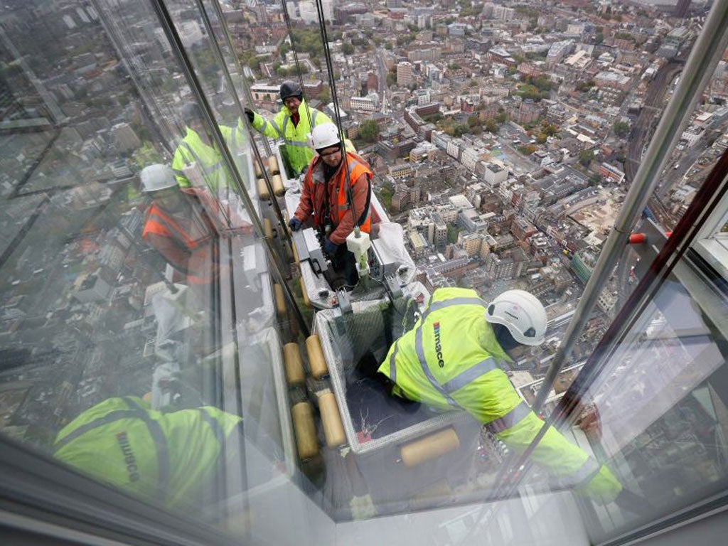 Workers clean the windows of the Shard