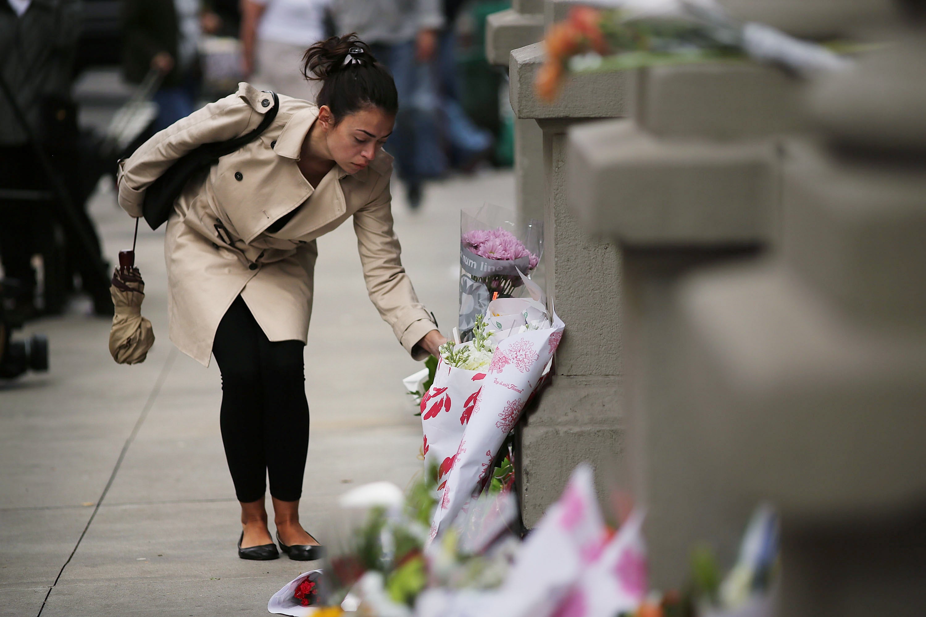 A woman leaves flowers at the Upper West Side apartments where two children were fatally stabbed