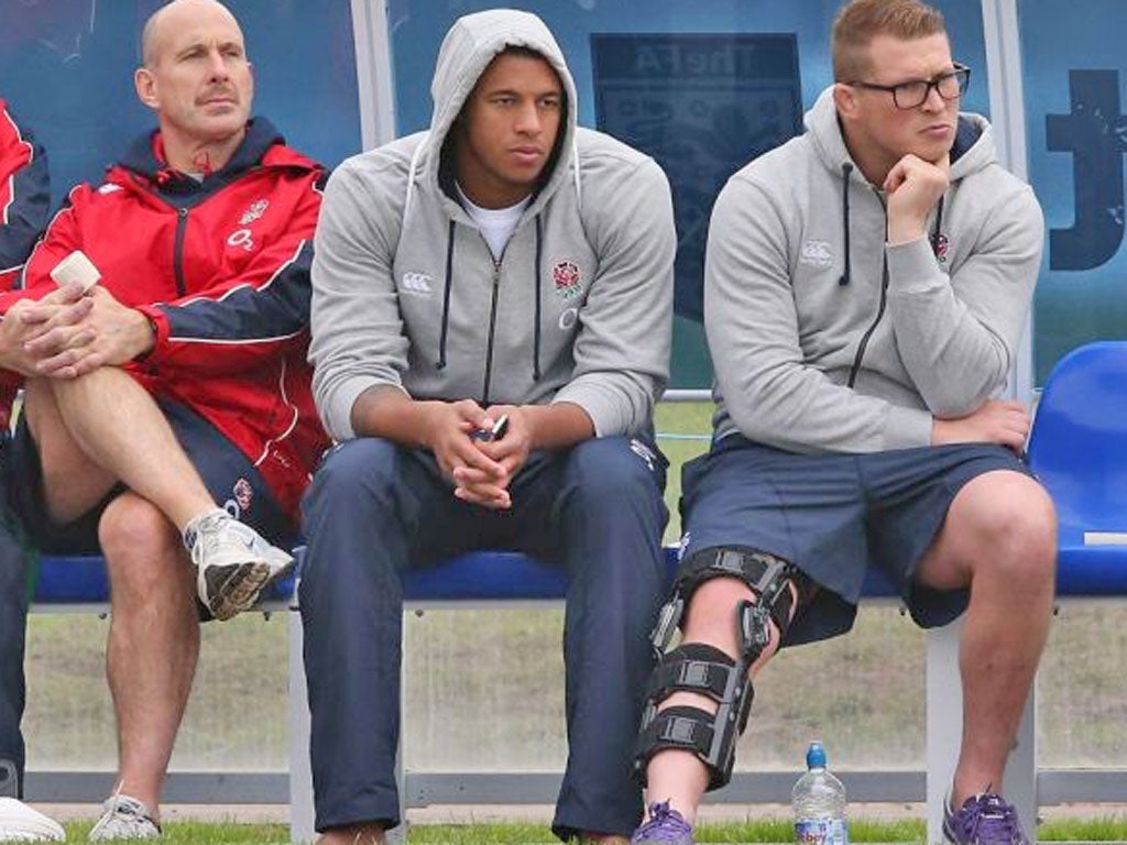Leg heavily strapped, Dylan Hartley watches England training yesterday with Courtney Lawes
