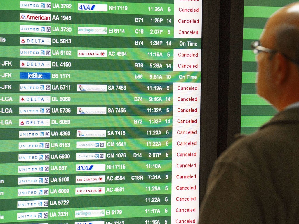 A man reviews the arrival flights at Dulles International Airport as the end of Hurricane Sandy rolls through the Washington, DC area