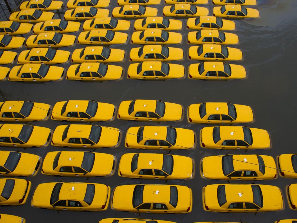 A flooded parking lot full of yellow cabs