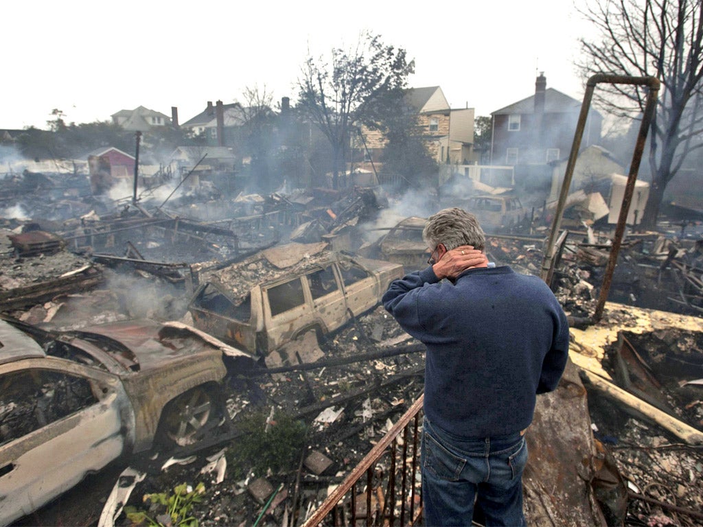 A homeowner surveys the wreckage of burned out homes in Breezy Point, New York