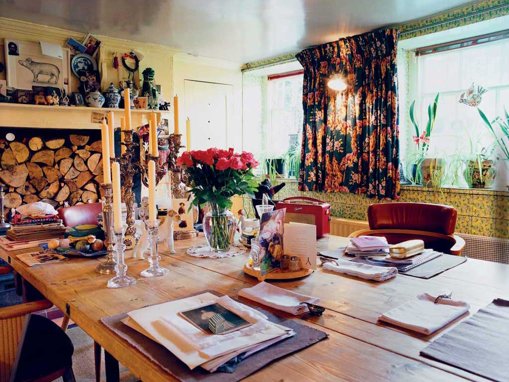 The 1930s chintz tiles lining Vivienne Westwood's basement kitchen were here when she moved in. A black-patterned Ermin print from a Westwood Gold Label show was used to make the curtains. Books and papers are much in evidence, along with a red Roberts radio - Vivienne is a great fan of Radio 4