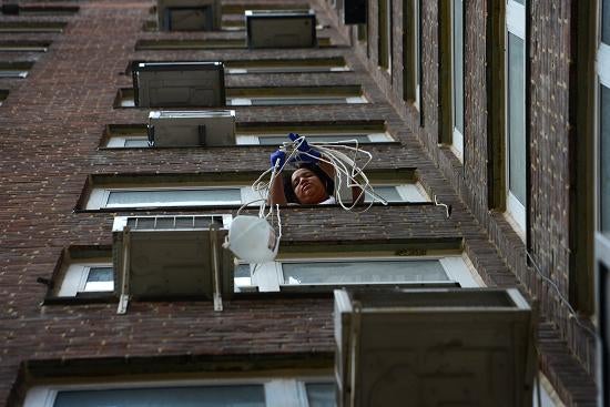 STORM PROJECTS: Bianca Nolasco uses a long rope to hoist gallons of fire hydrant water up to her fifth-floor apartment Thursday in New York. Several women used the rope method to bring water up to avoid a going up a dark and wet staircase in a housing project in the city's East Village near the ConEd substation that blew up during the storm.