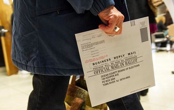 An Ocean County voter in Toms River, New Jersey, carries her completed ballot in an envelope, in a special early mail voting arrangement to allow citizens of the areas affected by Hurricane Sandy to vote in person on short notice in the US national and lo