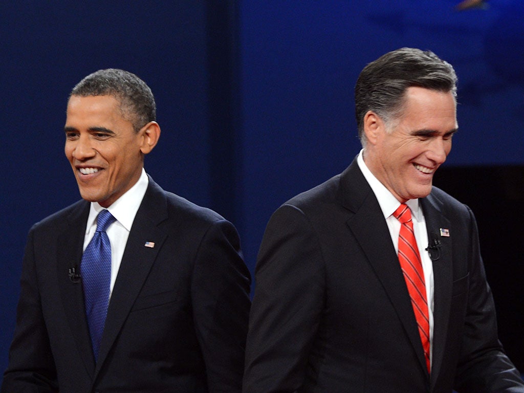 US President Barack Obama (L) and Republican presidential candidate Mitt Romney finish their debate at the University of Denver in Denver, Colorado, October 3, 2012.