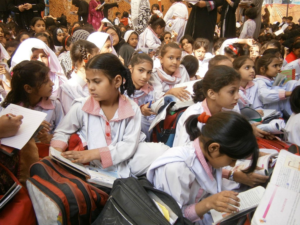 Students take lessons on the pavement outside the Farooqi school