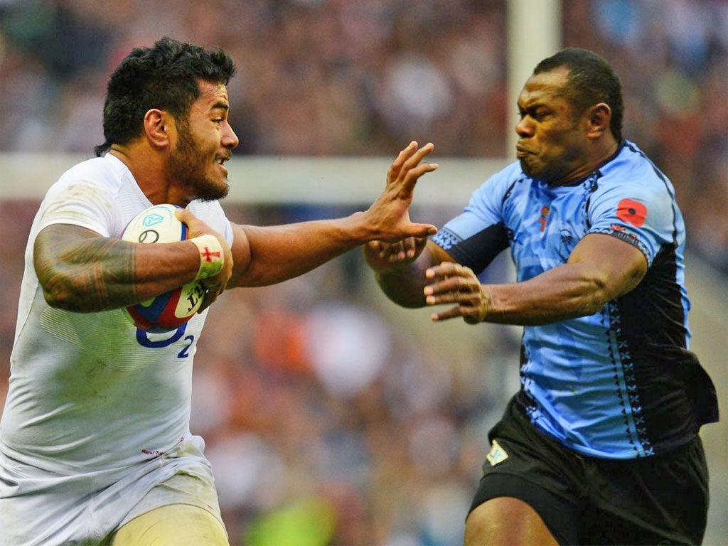 Manu Tuilagi of England hands off Vereniki Goneva of Fiji during the QBE international match between England and Fiji at Twickenham Stadium