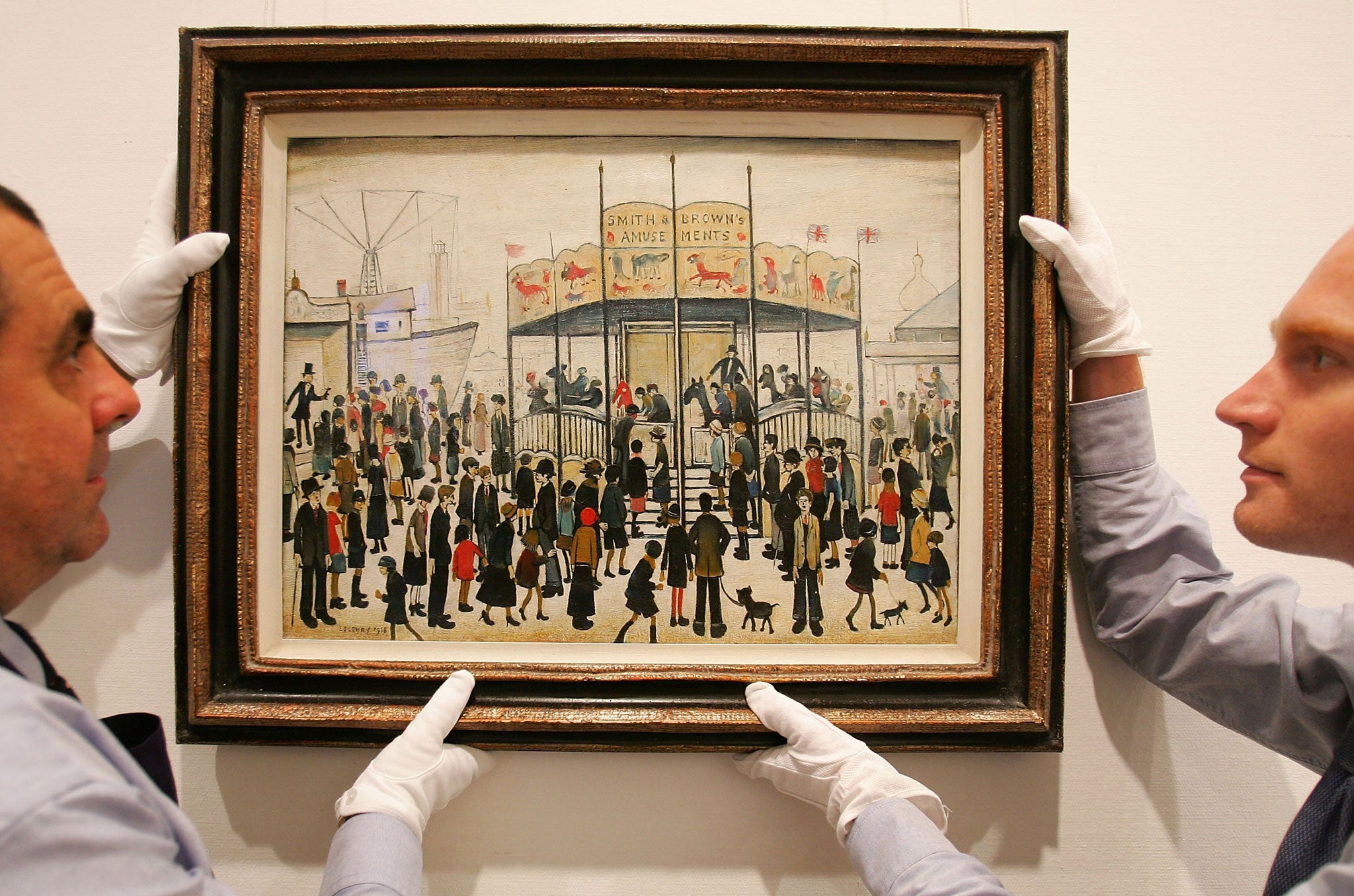 Sotheby's technicians hang Lowry's Fairground on August 22, 2007 in London, England.