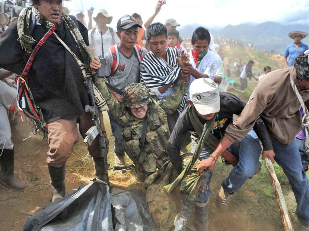 Indigenous Colombians drag a soldier from a military post on Mount Berlin. They expelled troops from the area after harassment by Farc guerrillas