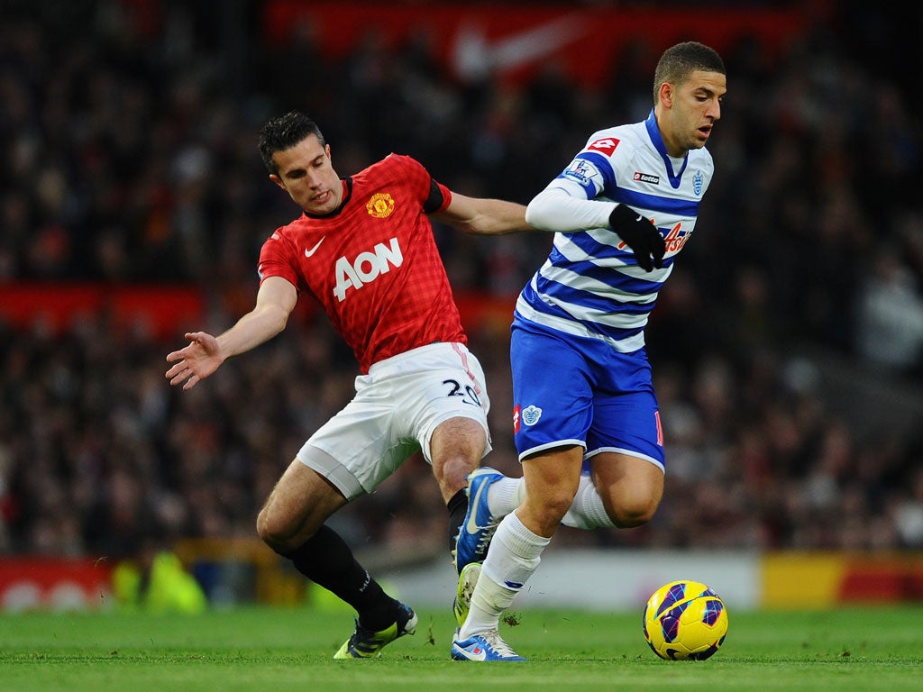 Robin van Persie of Manchester United competes with Adel Taarabt of Queens Park Rangers