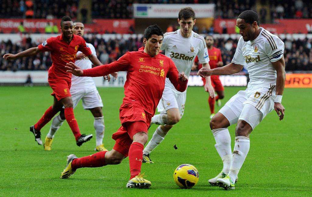 Luis Suarez of Liverpool competes with Ashley Williams of Swansea City