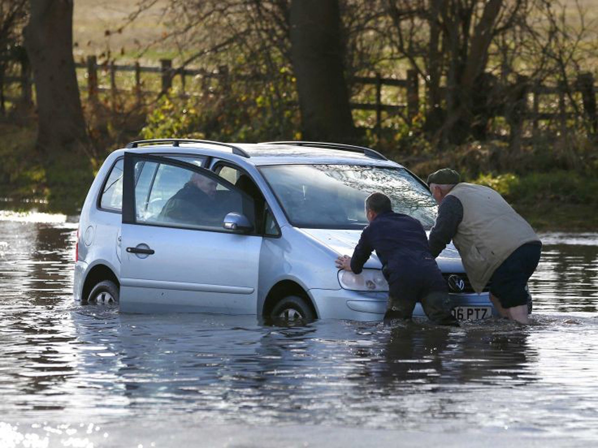 Men push a car out of flood water in Hathern, central England