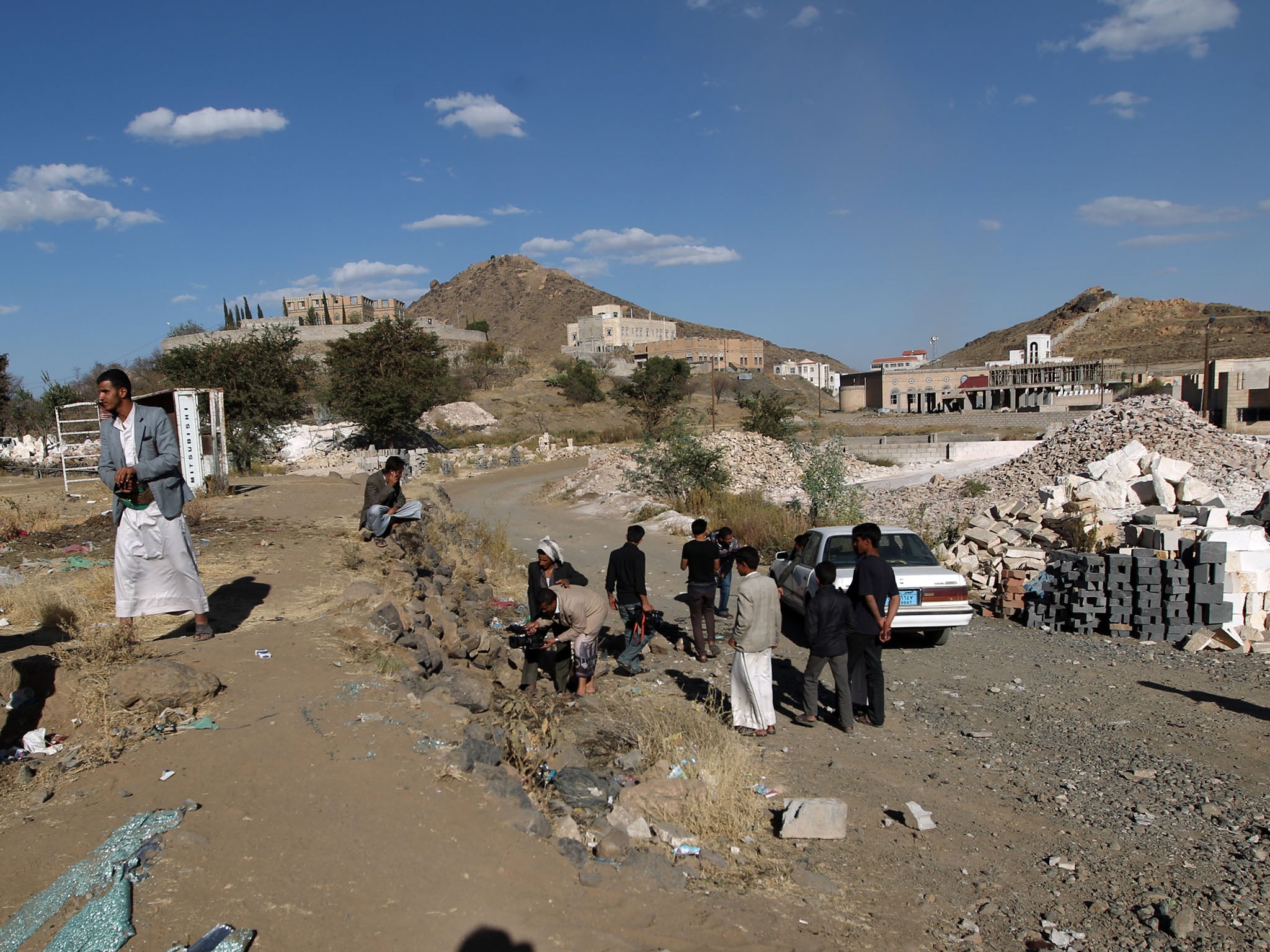 Yemeni men inspect the site where a Saudi diplomat and his bodyguard were killed in Sanaa's southern district of Hada, where embassies and diplomats' residences are located