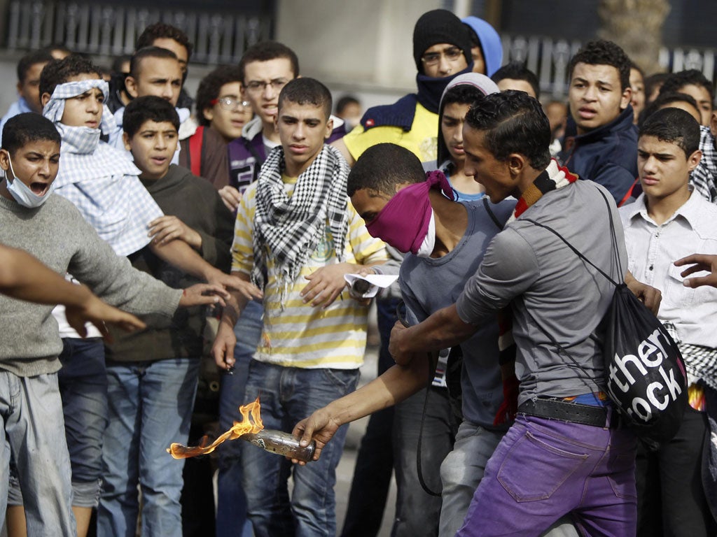 An anti-Morsi protester clashes with a youth in Cairo yesterday