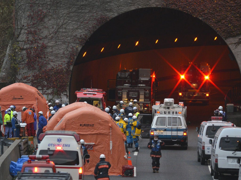 Rescue workers from police, fire department and highway authorities work at the entrance the the Sasago tunnel