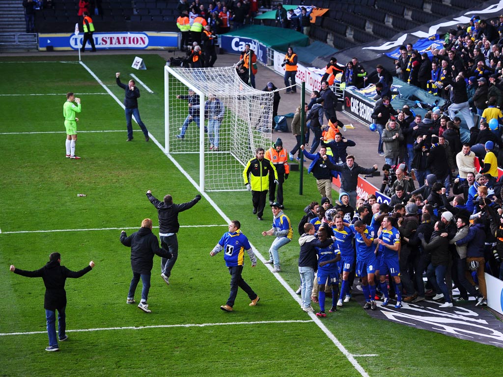 AFC Wimbledon fans spill onto the pitch