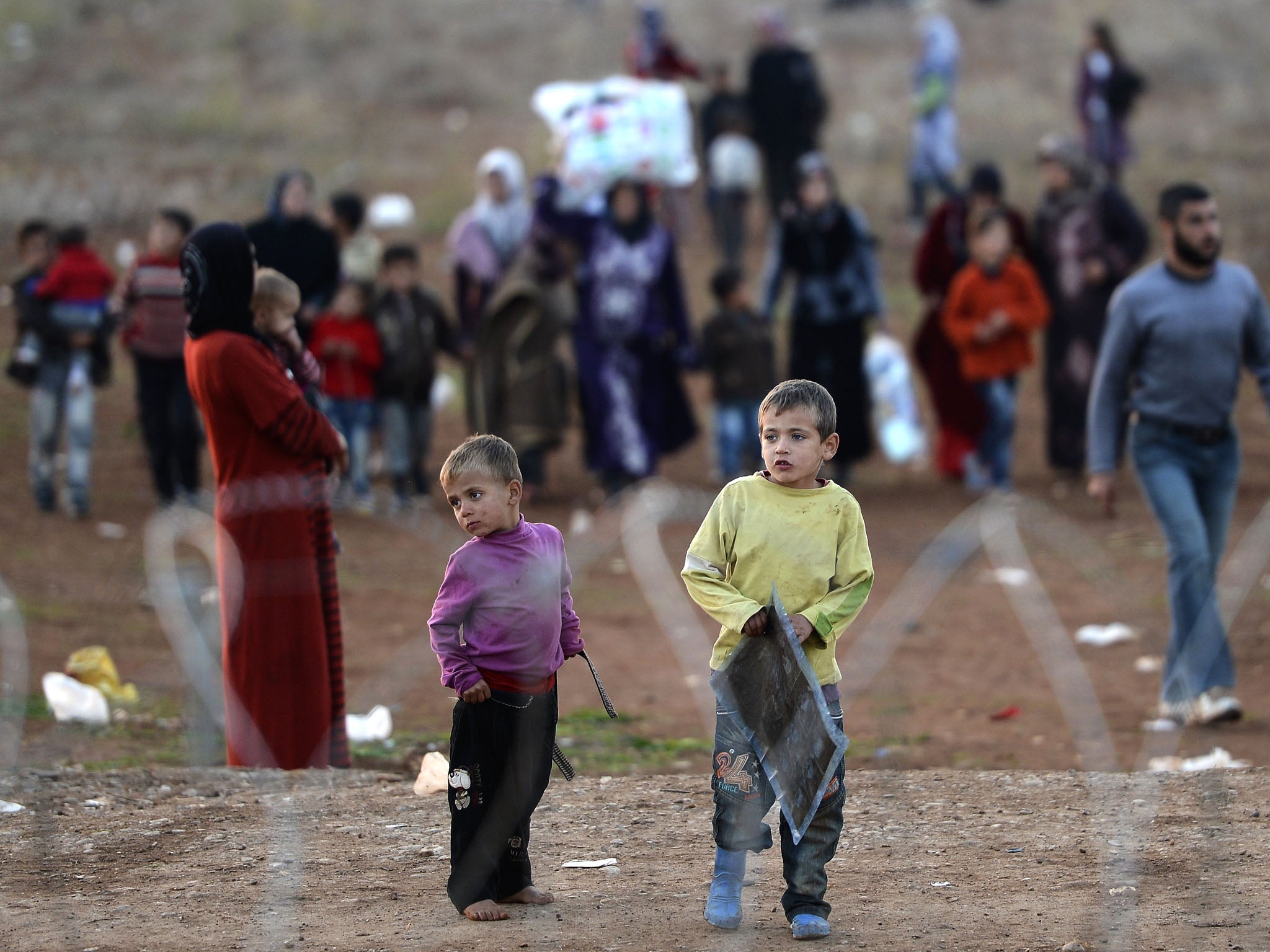 Syrian refugees are seen on the Turkish side of the border, close to the village of Atme, in neighboring Syria's northwest Idlib province