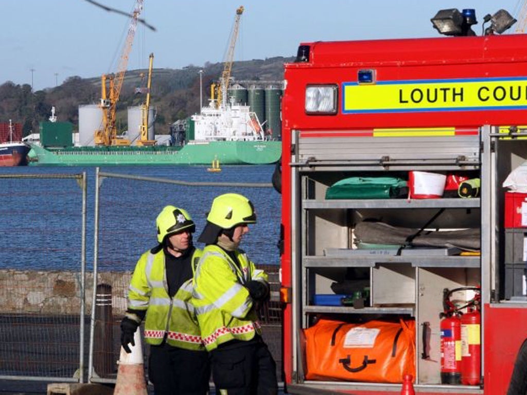 Firemen from Omeath in Co Louth, monitor the MV Arklow Meadow, which remains cordoned off at Warrenpoint harbour