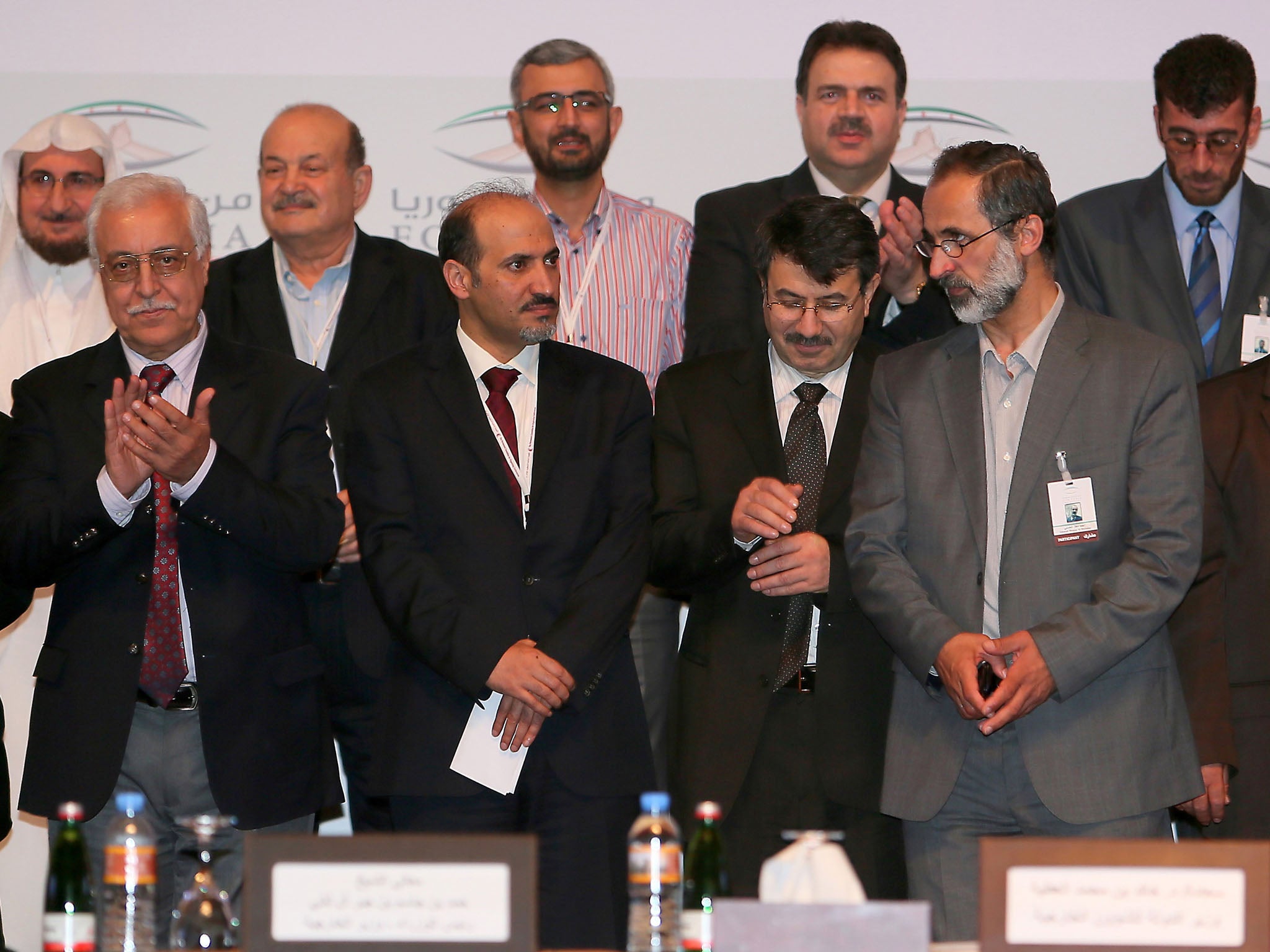 Participants pose for a group picture during a meeting to form a new Syrian opposition group called the National Coalition of Forces of the the Syrian Revolution and Opposition