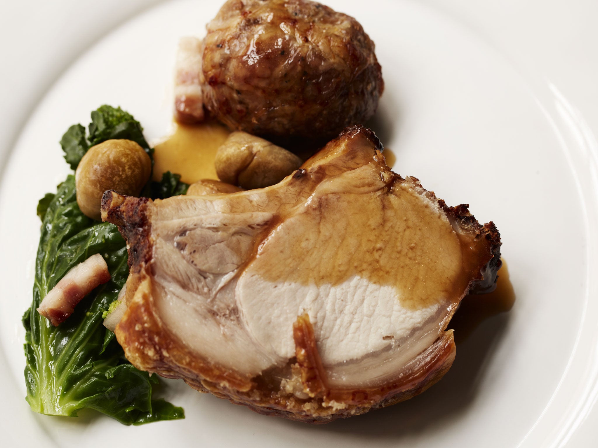 Roast rib of pork with apple dumplings, greens and chestnuts with easy-to-prepare gravy