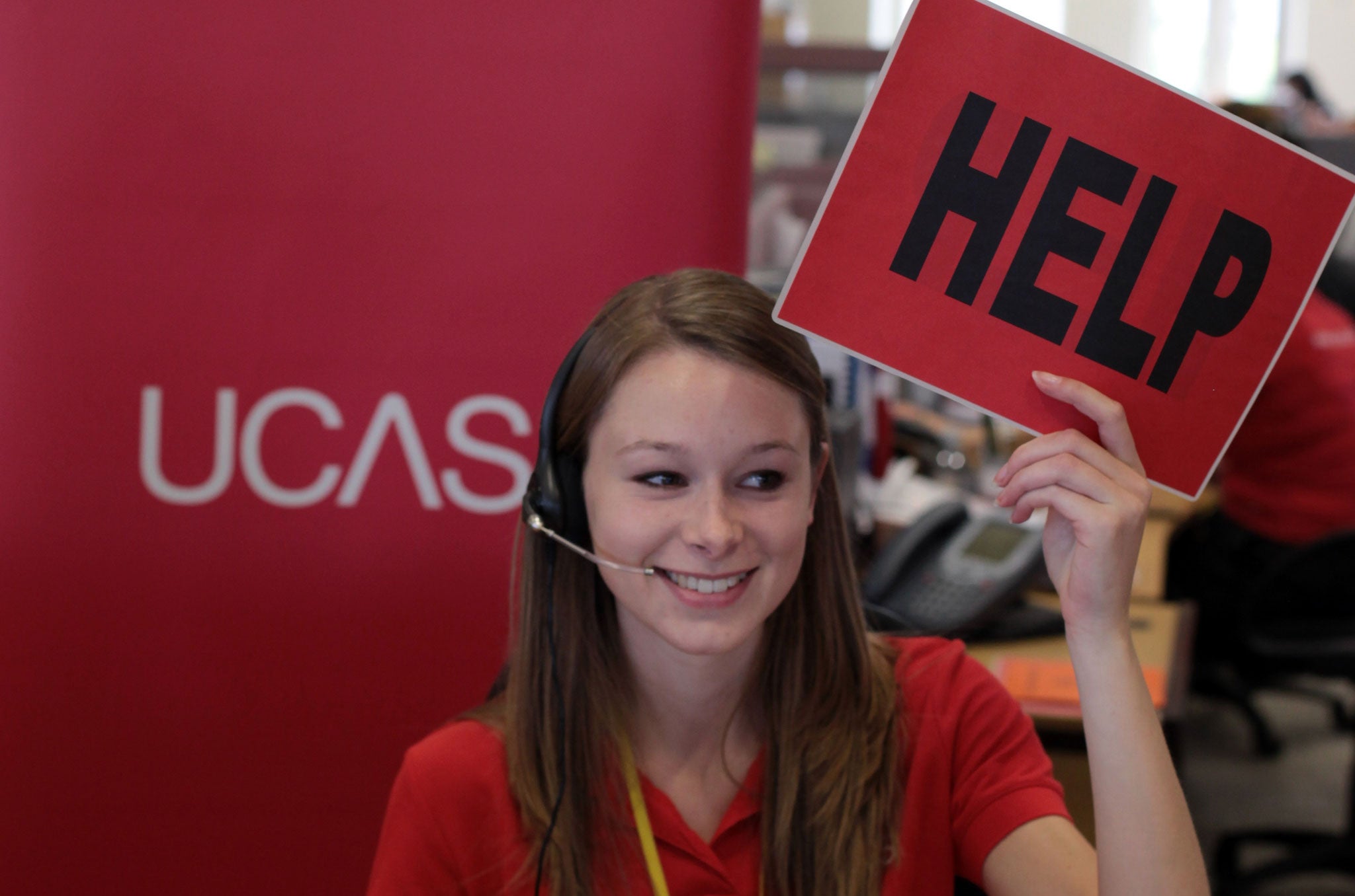 Sam Wathen, an employee in the UCAS clearing house call centre calls for assistance and advice from a supervisor August 18, 2010 in Cheltenham, England.