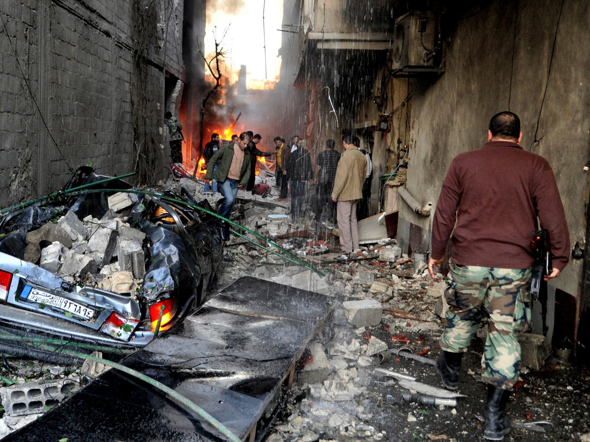 Close to home: Residents of Jaramana survey the damage left by two car bombs