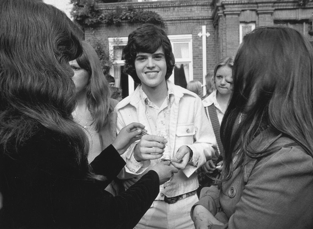 American pop idol Donny Osmond signs autographs for a handful of admiring fans.