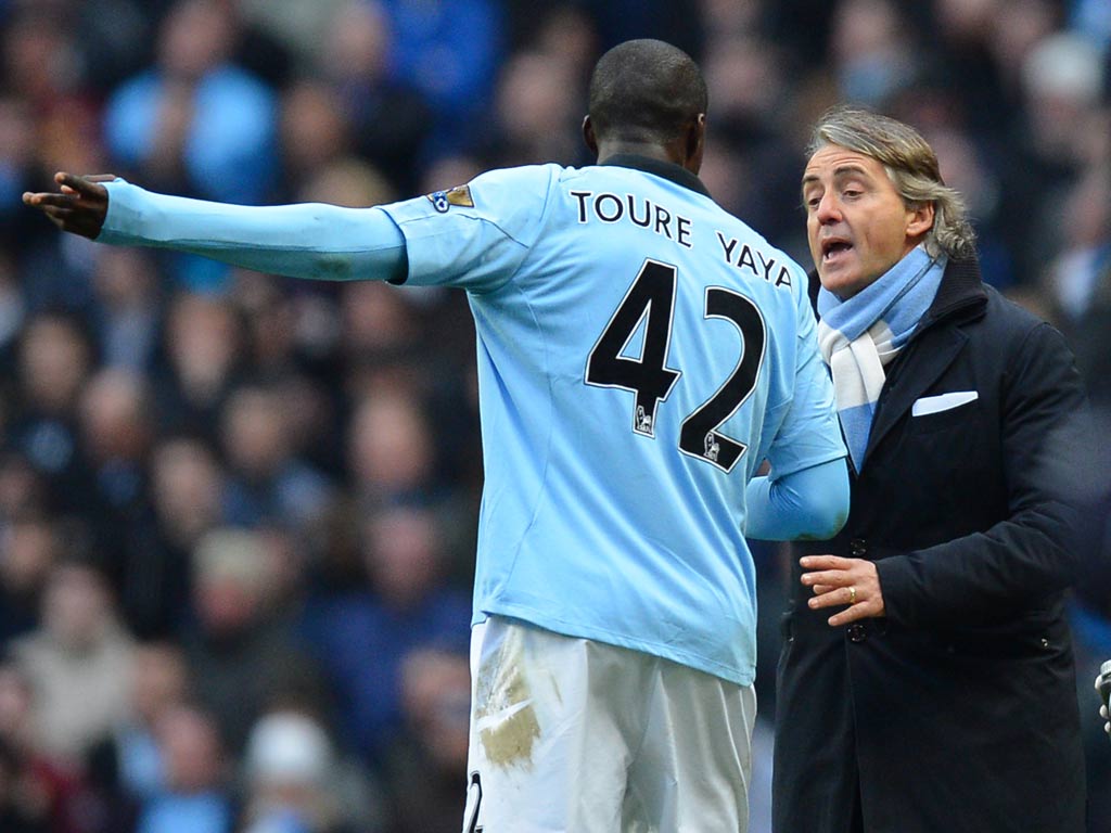 Yaya Toure talks with Roberto Mancini