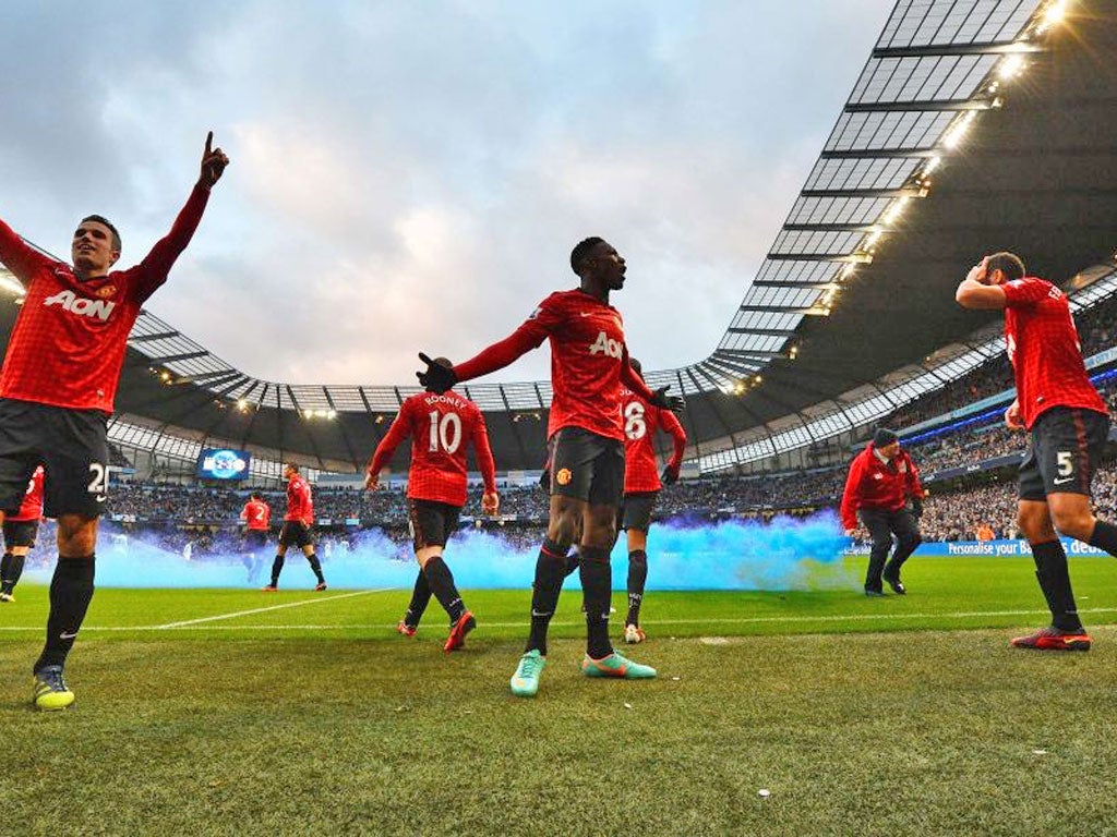 Manchester United players celebrate Robin van Persie’s (left) late
winning goal as Rio Ferdinand holds his head after being struck by a coin thrown from the crowd