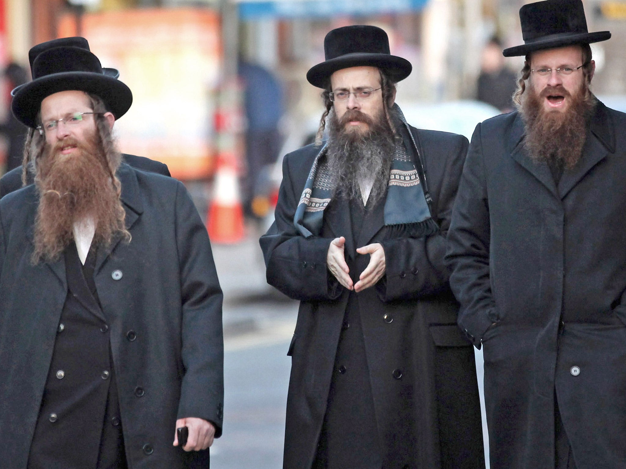 Jewish men walk along the street in the Stamford Hill area of north London