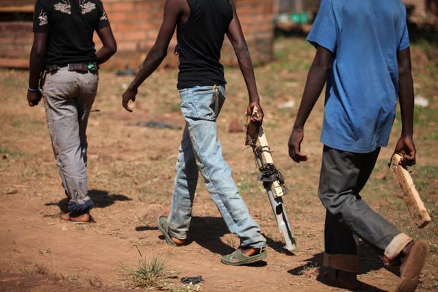 During the role-play, some of the children act out the part of the militiamen. They create imitation weapons out of pieces of wood and plastic.