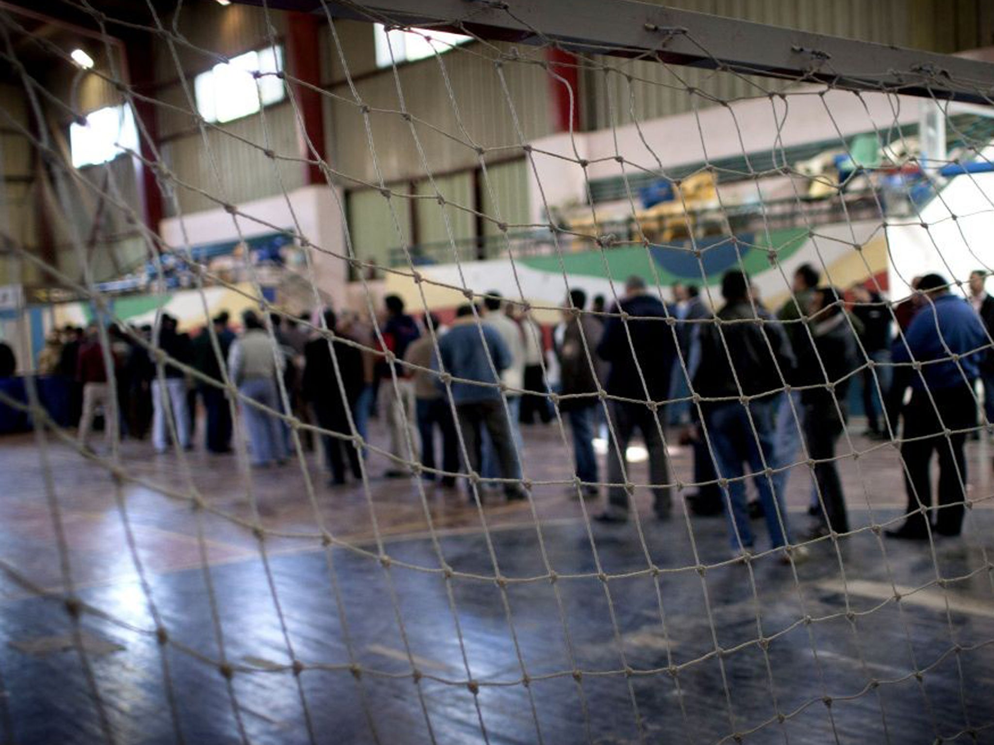 Egyptians wait to vote at gymnasium hall that is used as a polling station