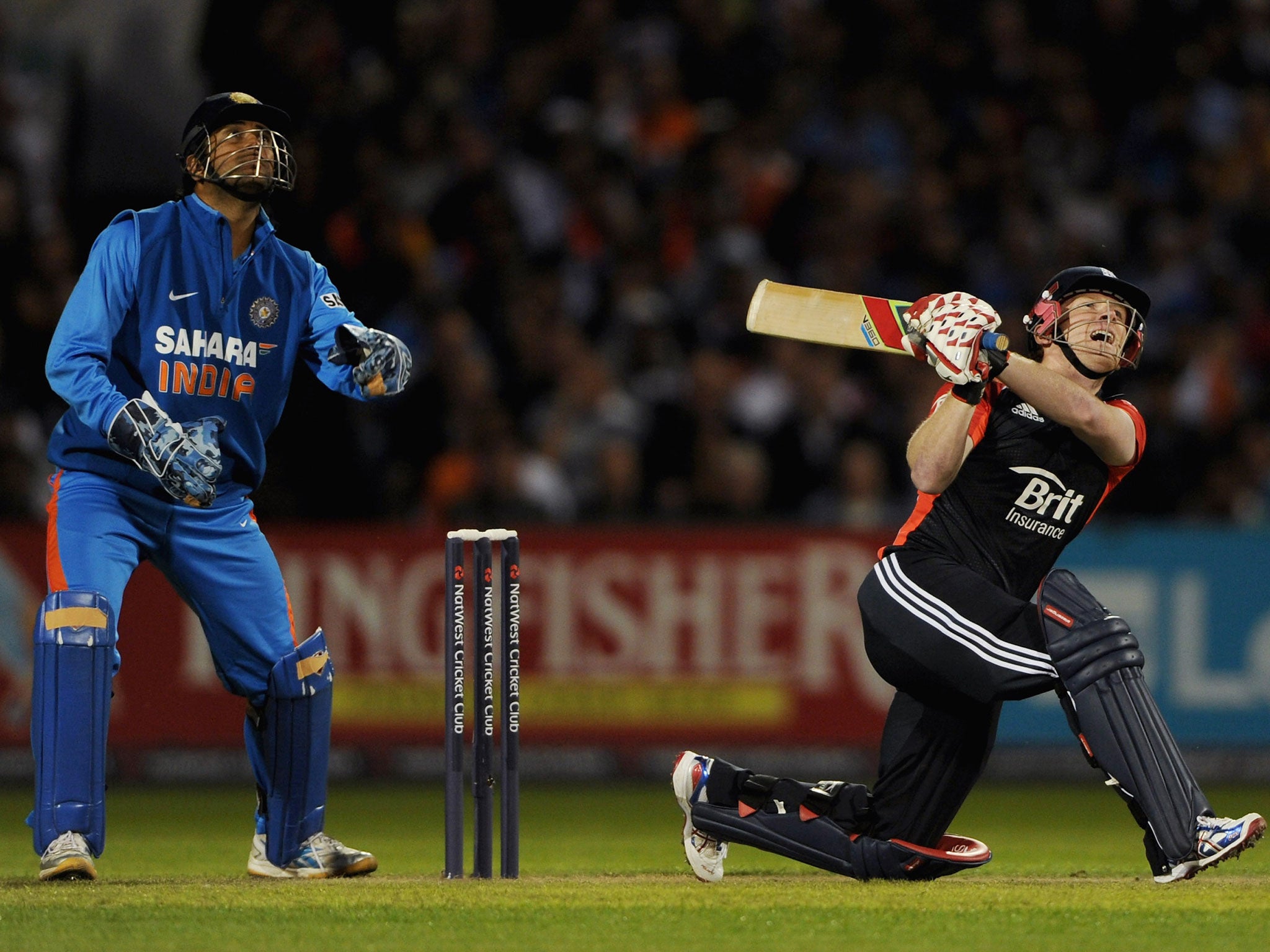 Eoin Morgan of England bats watched by Indian wicketkeeper MS Dhoni