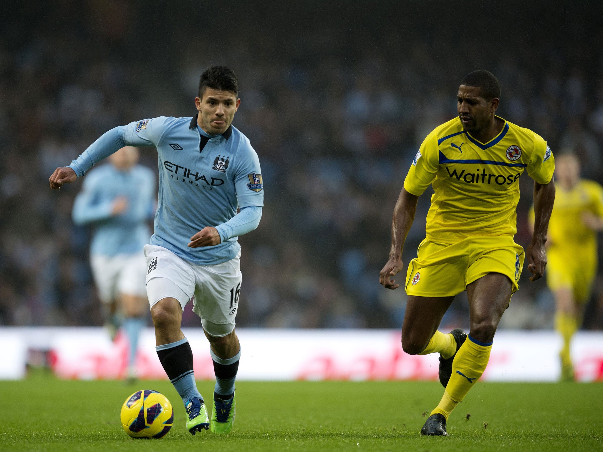 Manchester City's Argentinian striker Sergio Aguero (C) runs with the ball against Reading