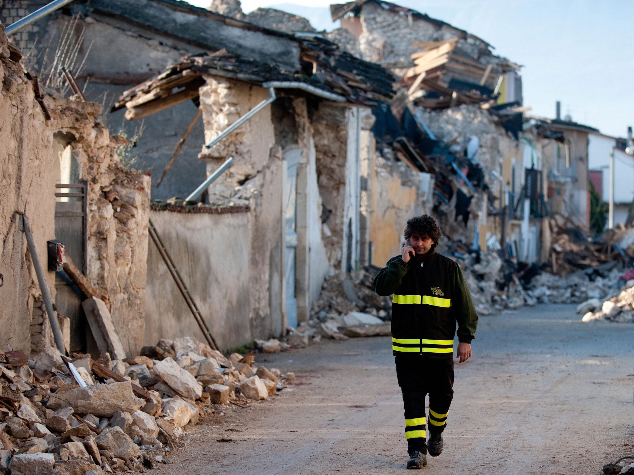 A firefighter walks near a genuine epicentre, the epicentre of the April 6, 2009 earthquake, as opposed to The Scene "the epicentre of hip 1960s New York".