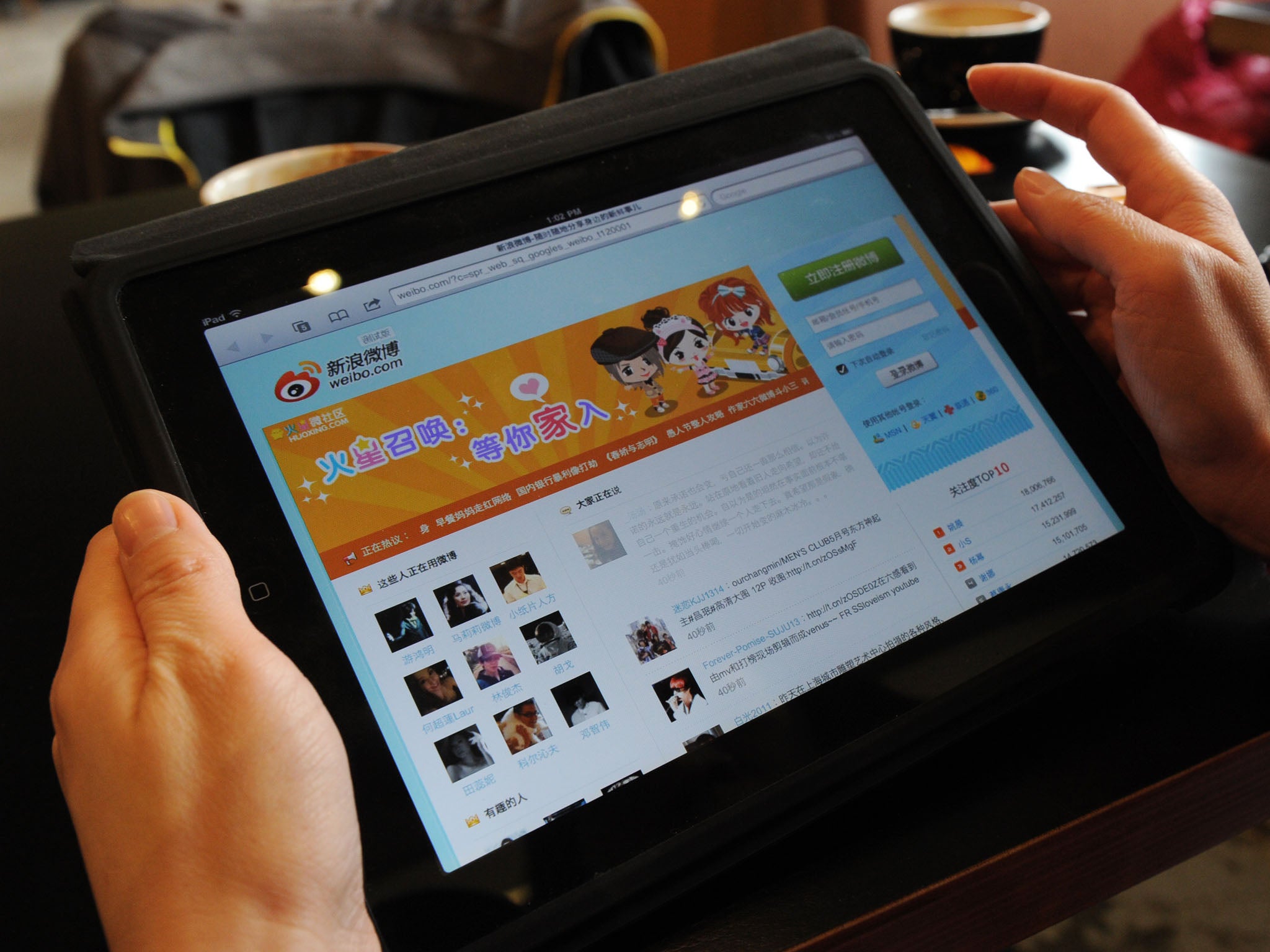 A woman views the Chinese social media website Weibo at a cafe in Beijing