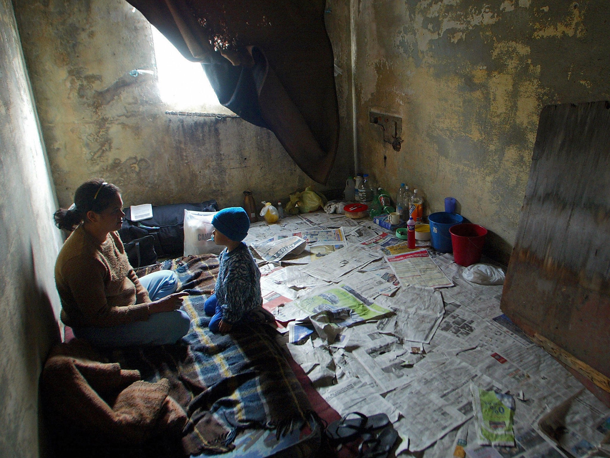 A mother talks to her son in their 'bedroom' in a vacant building of Rua Maua (Maua Street), in Sao Paulo, Brazil, 29 July 2003.