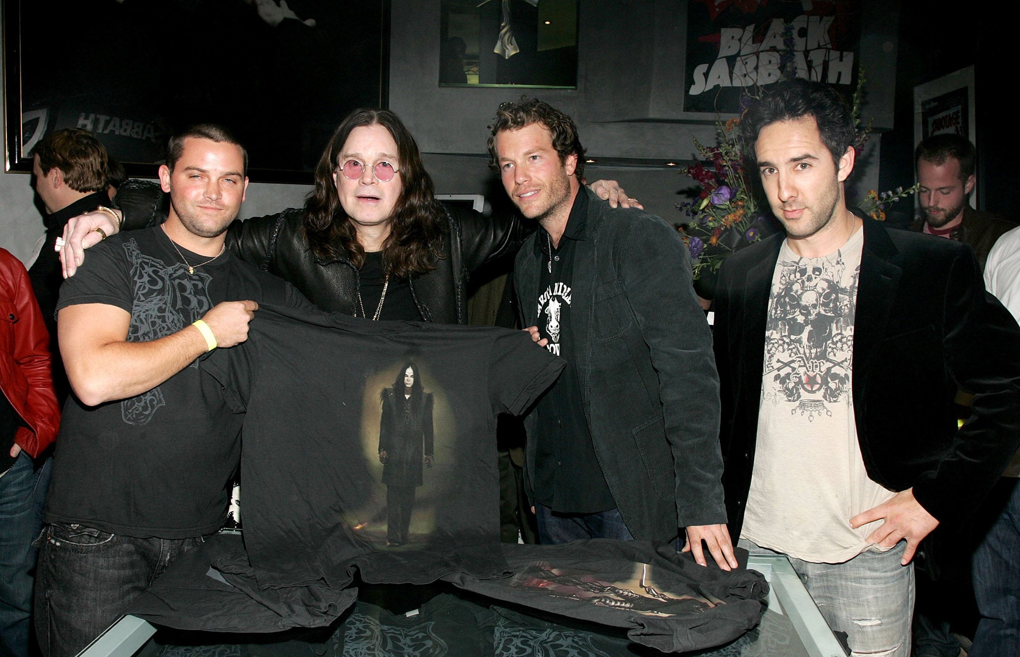 Black Sabbath holding up a T-shirt