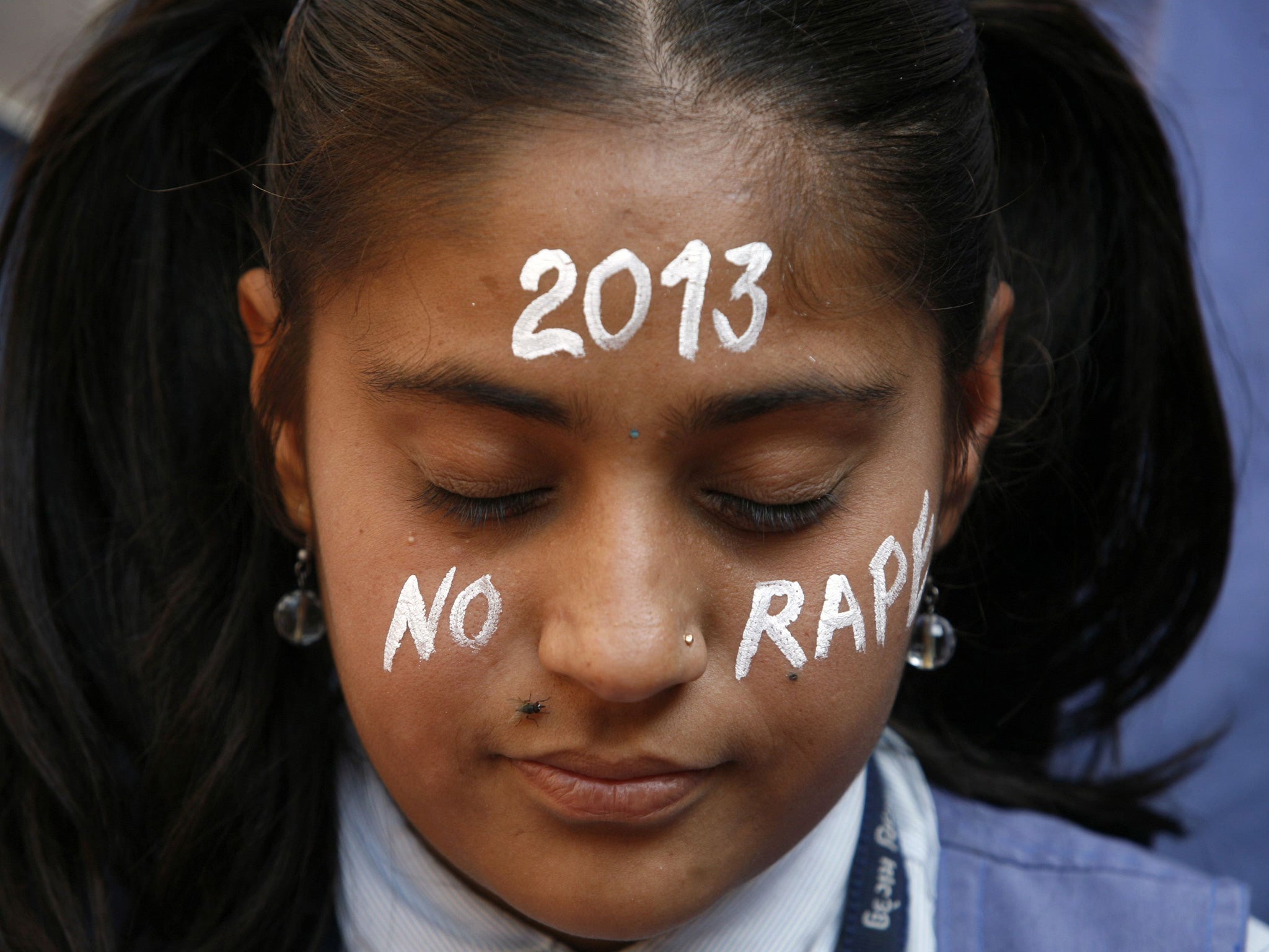 A student prays during a vigil in New Delhi