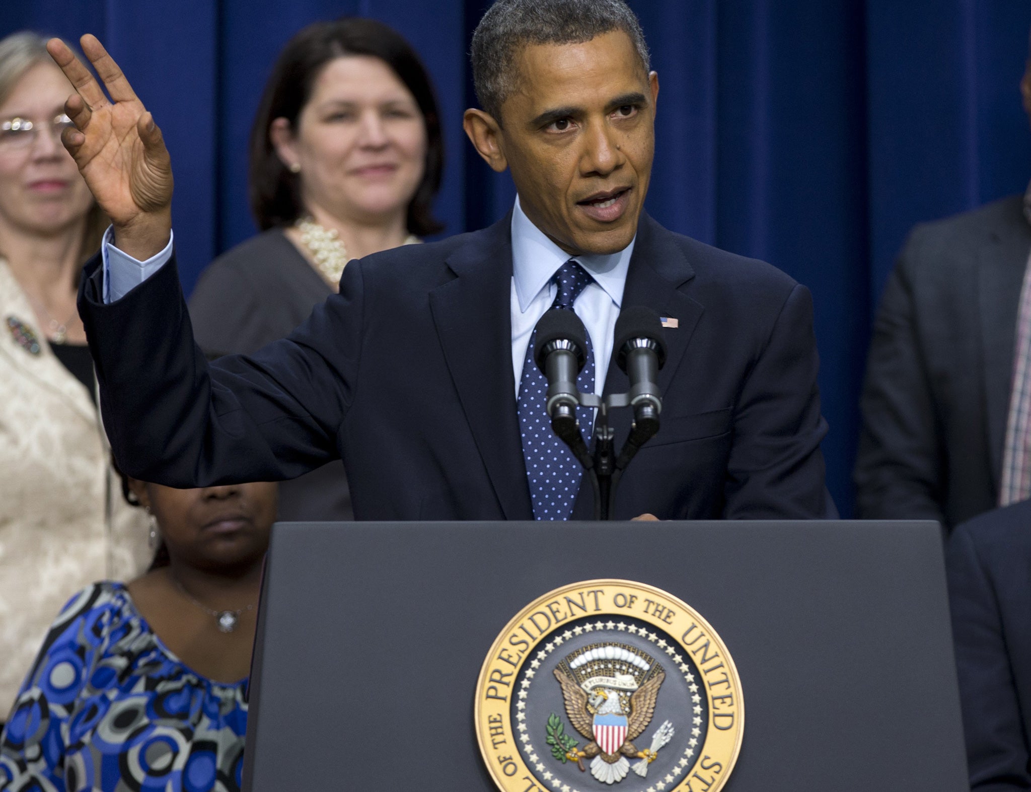 Barack Obama speaks at the White House last night flanked by a group of ‘middle-class Americans’