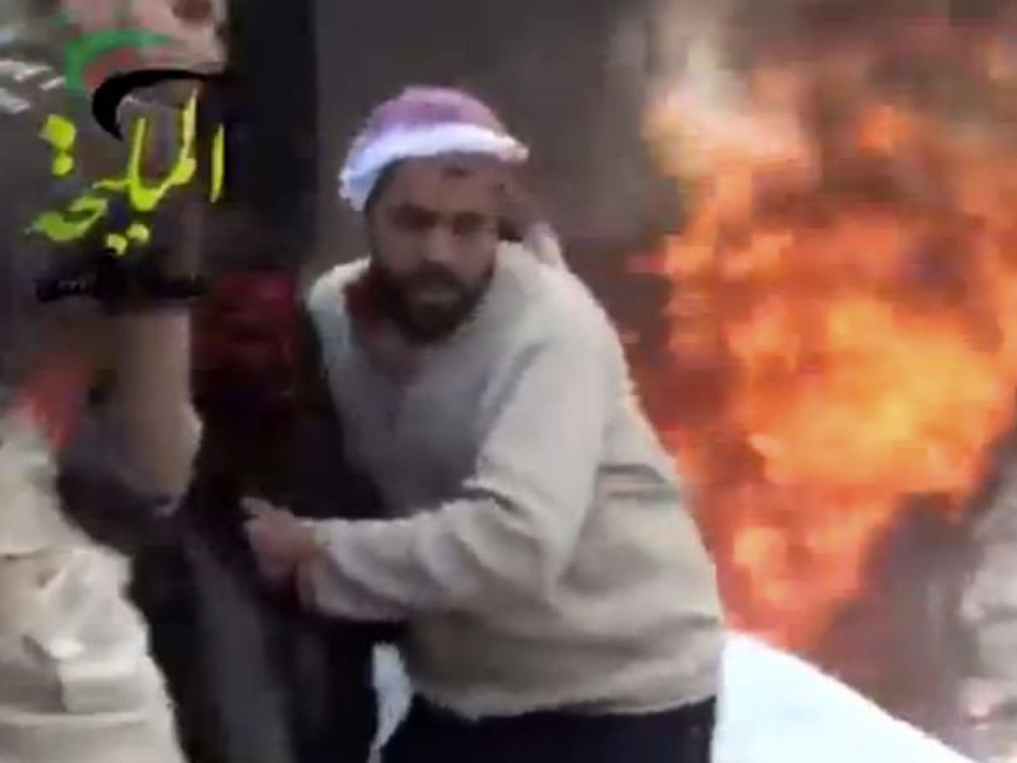 A wounded man is pulled from the site of a Syrian government airstrike on a petrol station in the eastern Damascus suburb of Mleiha