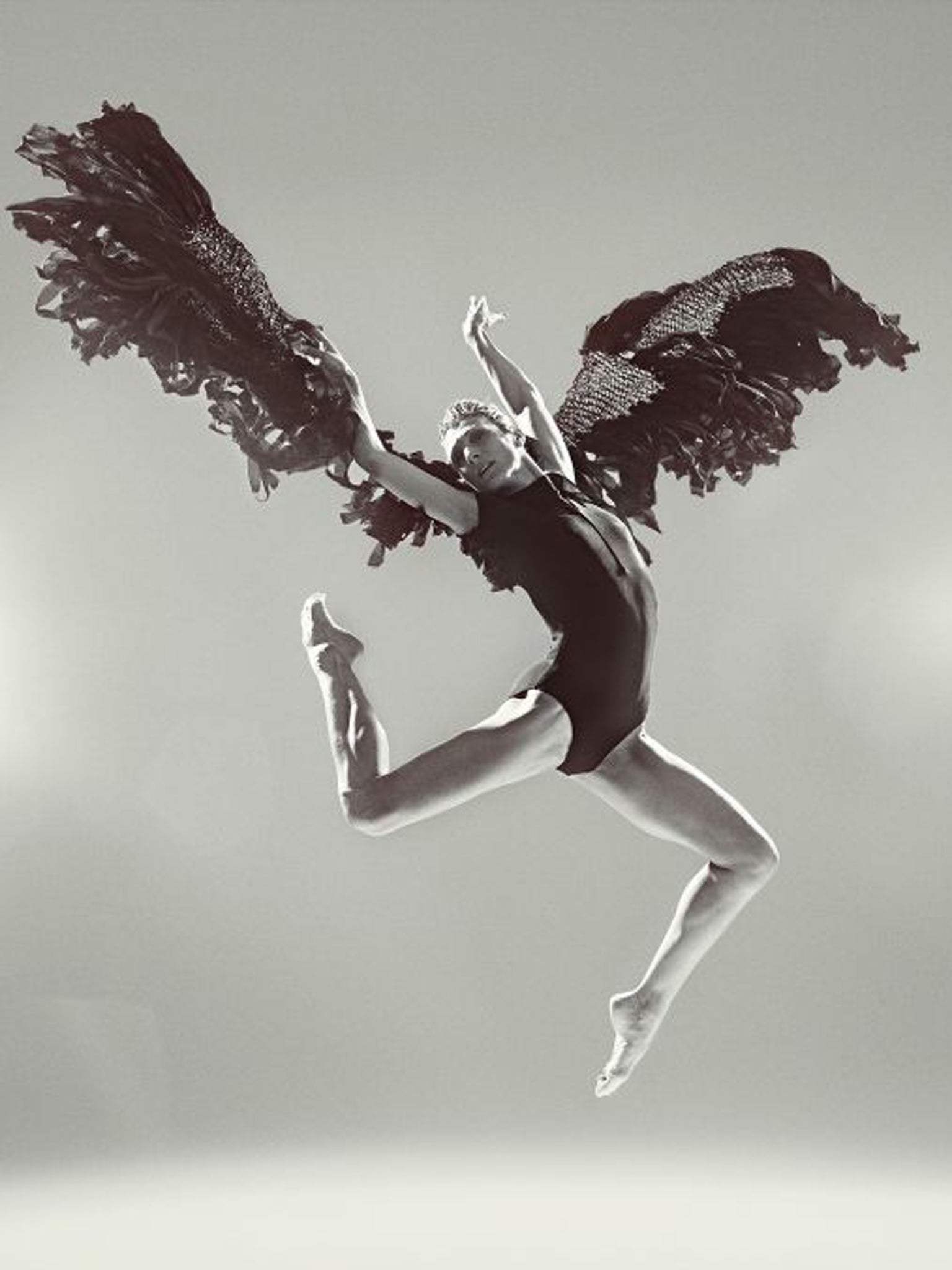 Zenaida Yanowsky leaping in a pair of woollen black wings