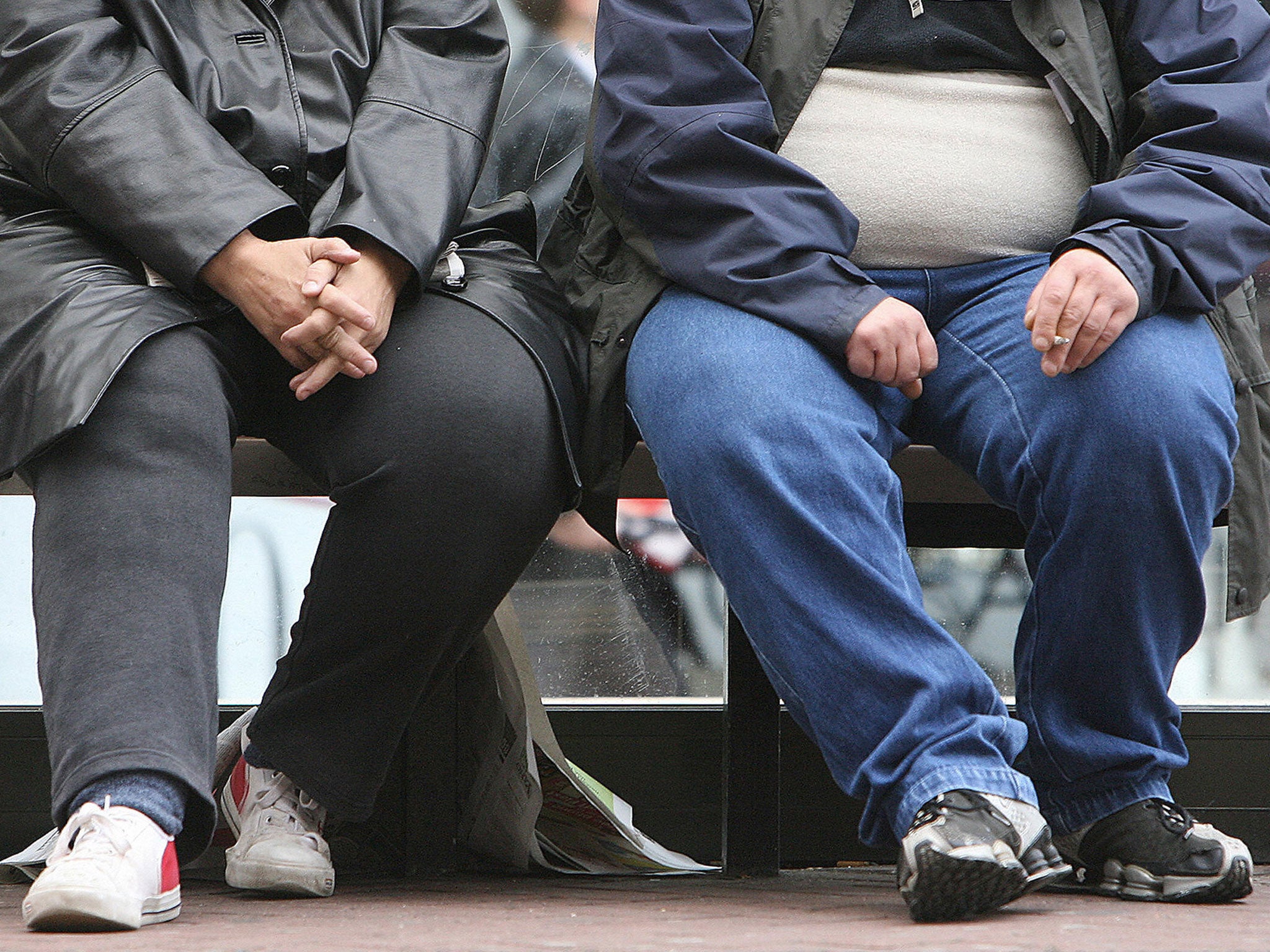 A man and a woman wait at a tram stop in Manchester, in north-west England, 10 October 2006.