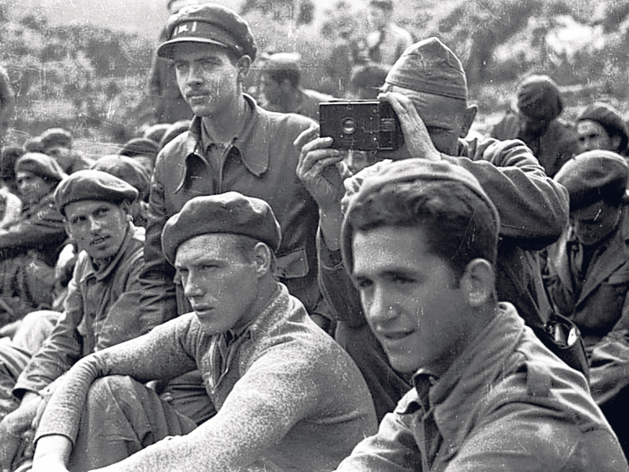 Randall, standing, left: 'We found ourselves acting as runners, ammunition carriers, guards, observers,' he said of his photographic unit