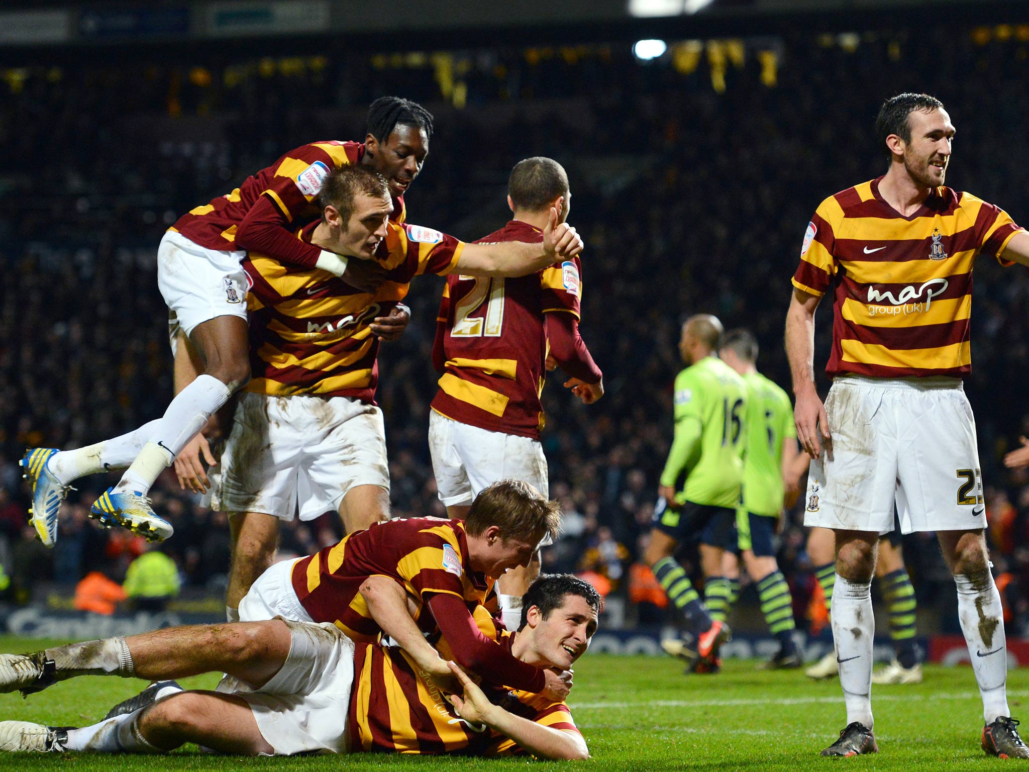 Bradford City's Irish defender Carl McHugh (bottom) celebrates with teammates after scoring the third goal